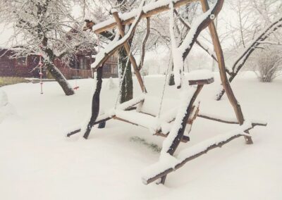 Drewniana huśtawka pokryta śniegiem